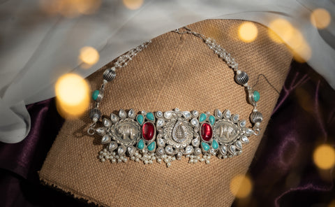 Dual elephant motifs with semi-precious red and turquoise stones, kundan-style white stones, and pearl drops