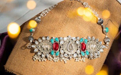 Dual elephant motifs with semi-precious red and turquoise stones, kundan-style white stones, and pearl drops